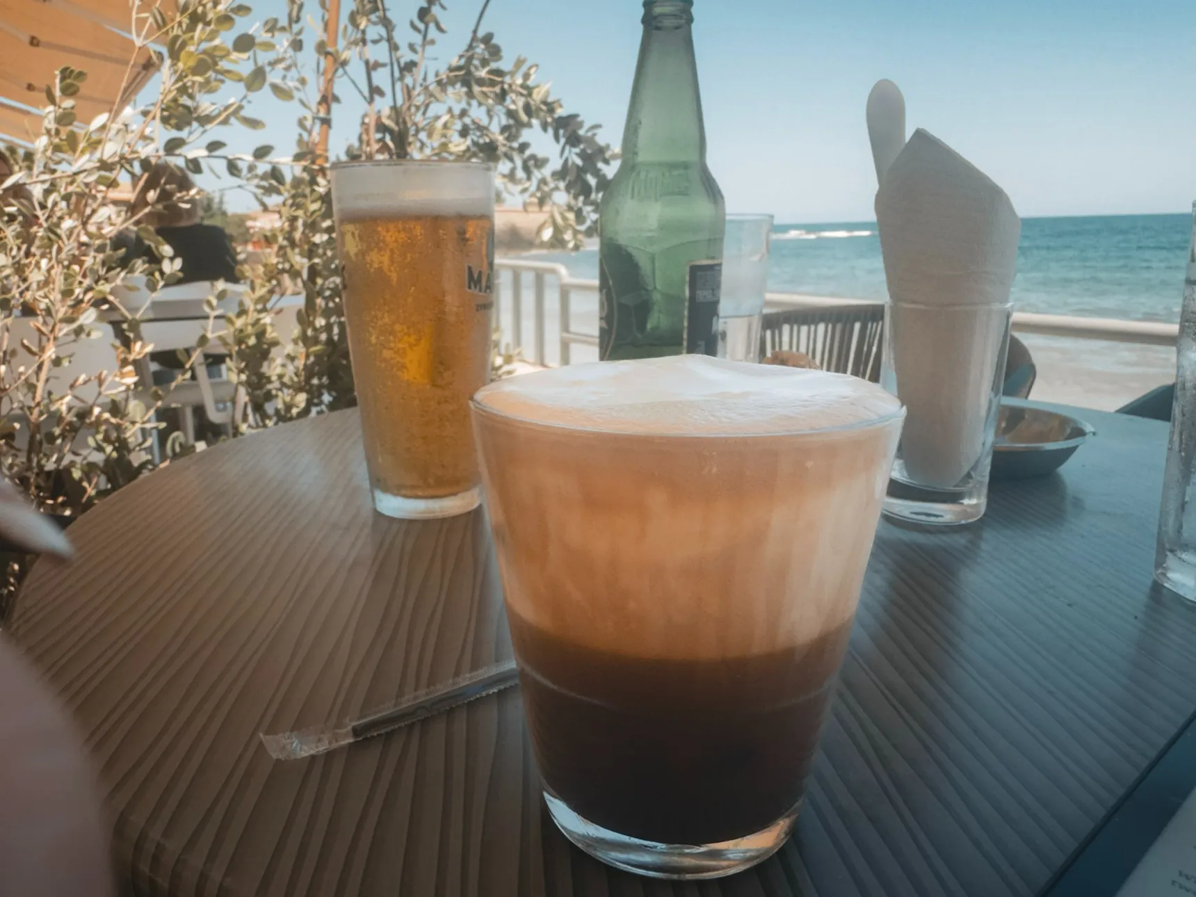 Freddo cappuccino overlooking Koum Kapi Beach at Prodigal Son