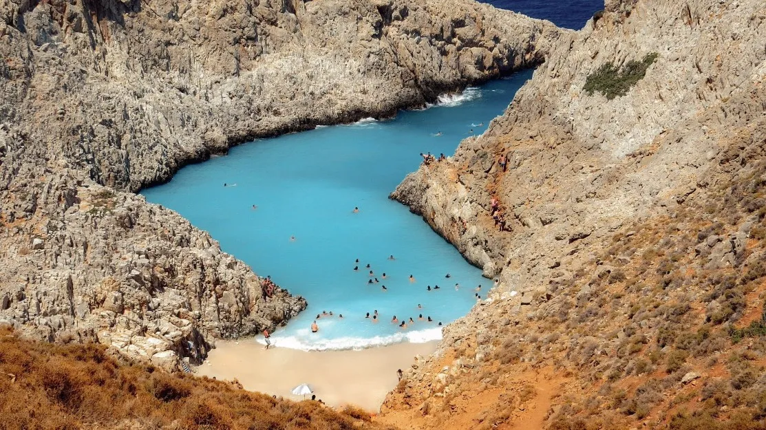 bright blue water of Seitan Limania, hugged by cliffs