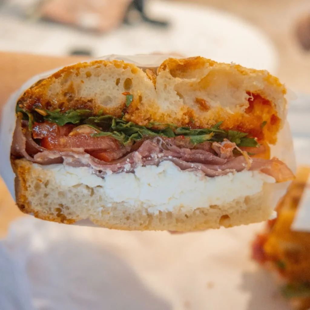 focaccia with mizithra cheese, prosciutto, tomato, rocket, chili jam