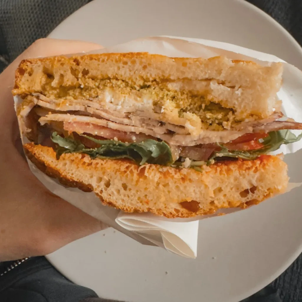 Freshly sliced porchetta focaccia sandwich at Wake & Bake, Chania