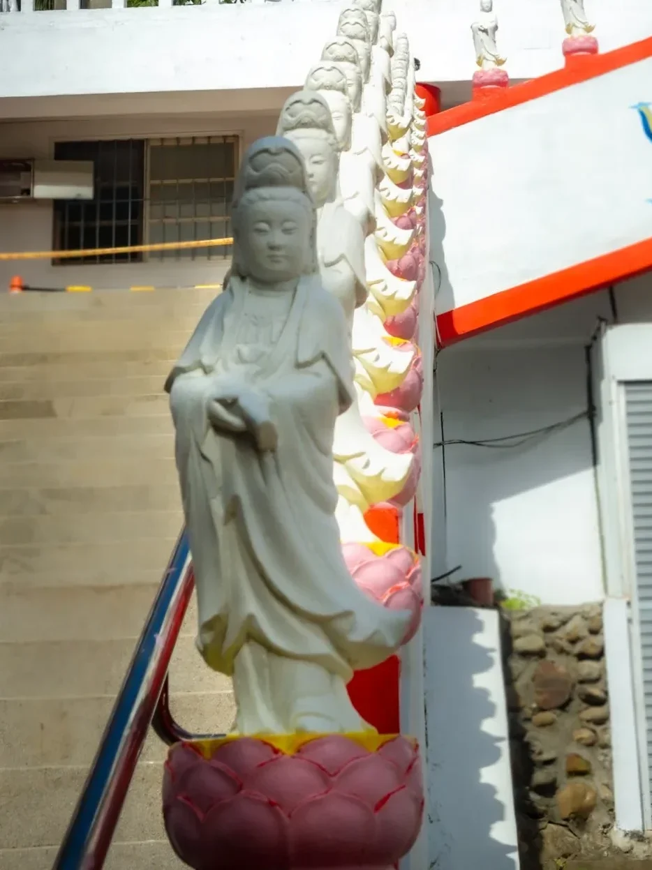 row of white standing buddhas on the staircase